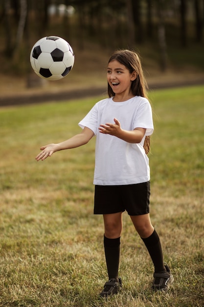 Kinderen voetballen onder toezicht van voetbaltrainer