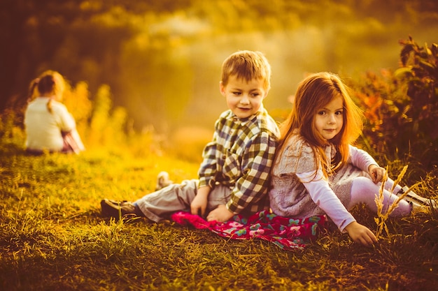 Kinderen zitten naast elkaar op een plaid