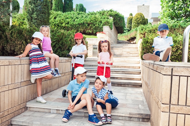 Kindermode concept. groep tiener jongens en meisjes poseren in het park. kleurrijke kinderkleding, lifestyle, trendy kleurenconcepten.