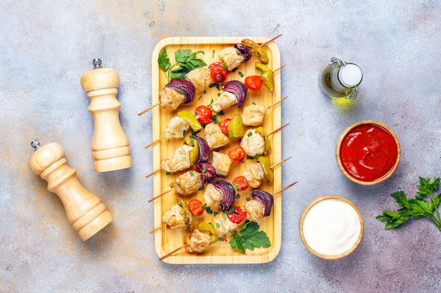 Kip shish kebab met groenten, ketchup, mayonaise, bovenaanzicht