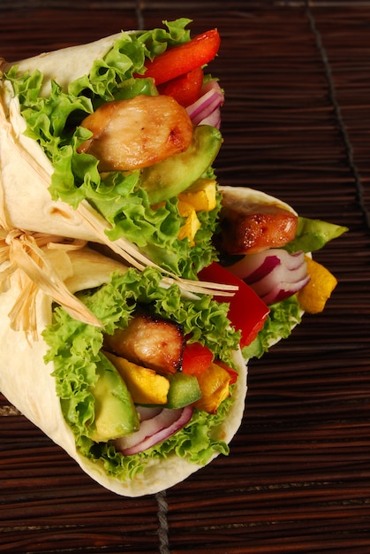 Kip wrap sandwiches op een houten mat