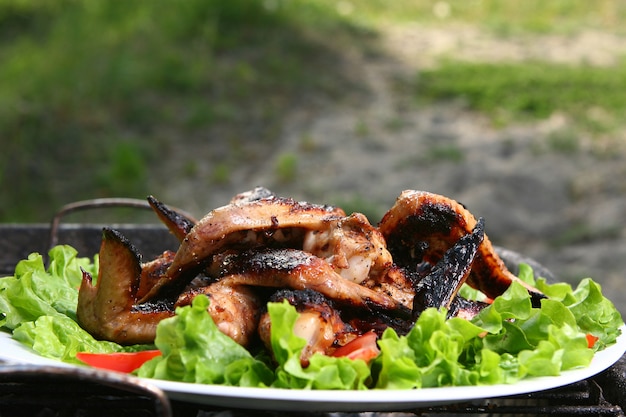 Gratis foto kippenbenen op de grill met groenten