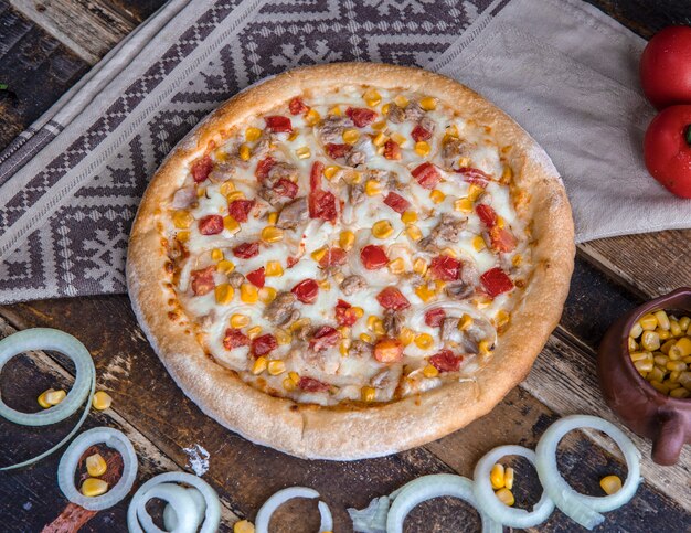 Kippenpizza met tomaten, uien en ranchsaus op de houten lijst