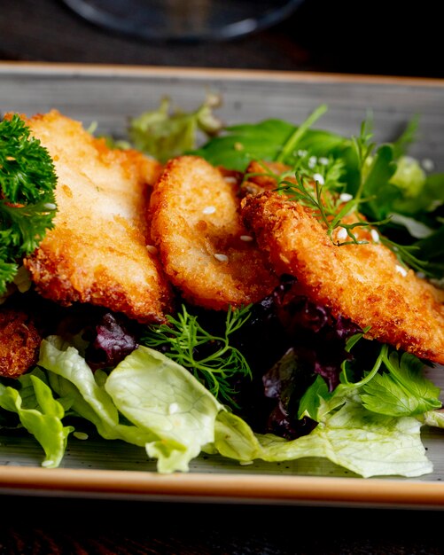 kippenschnitzel geserveerd met sla en greens