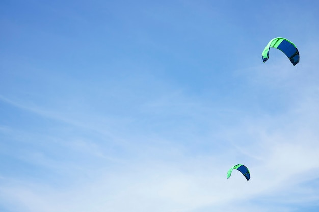 Kitesurfen op een oppervlak van blauwe lucht, plaats voor tekst.