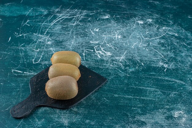 Kiwi's op snijplank, op de marmeren tafel.