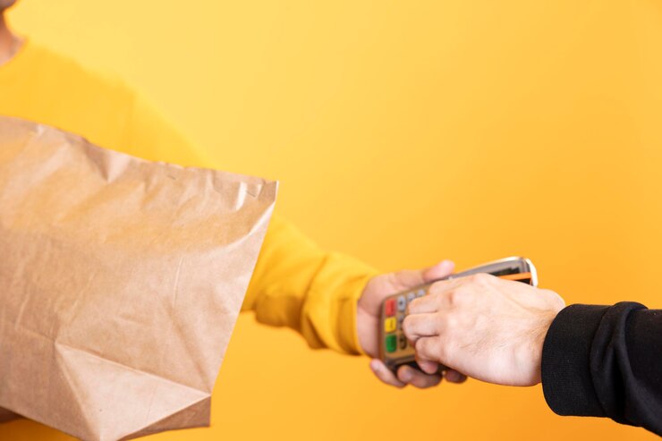Gratis Foto klant betaalt met een creditcard aan een parttime bezorger