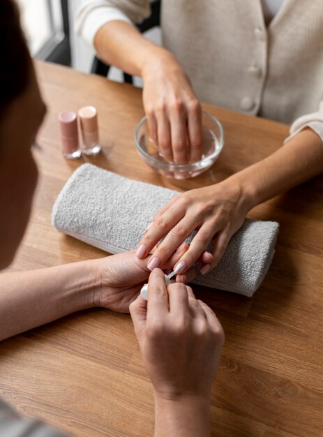 Klant bij manicure-afspraak hand in hand in kom