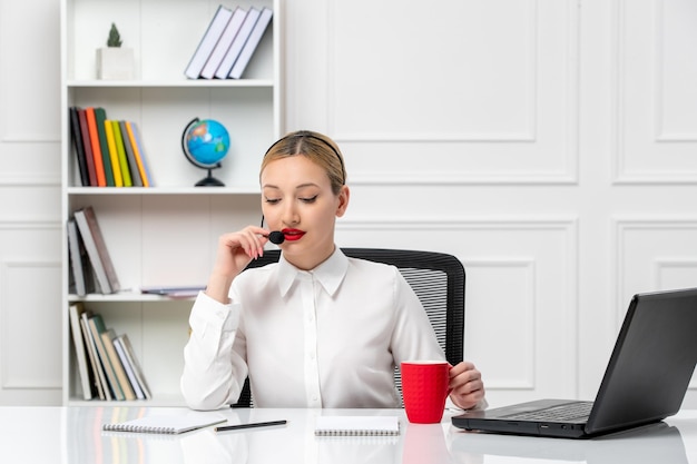 Gratis foto klantenservice mooi blond meisje in wit overhemd met laptop en headset in gesprek met een klant