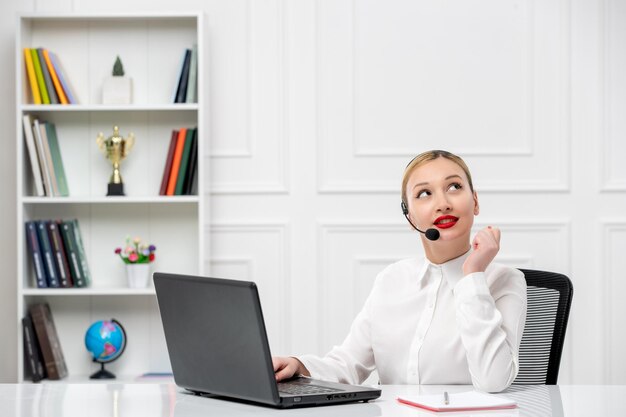 Klantenservice schattig blond meisje office shirt met headset en computer opzoeken en glimlachen