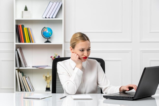 Klantenservice schattig meisje in wit overhemd met rode lippenstift en laptop denken en gefocust