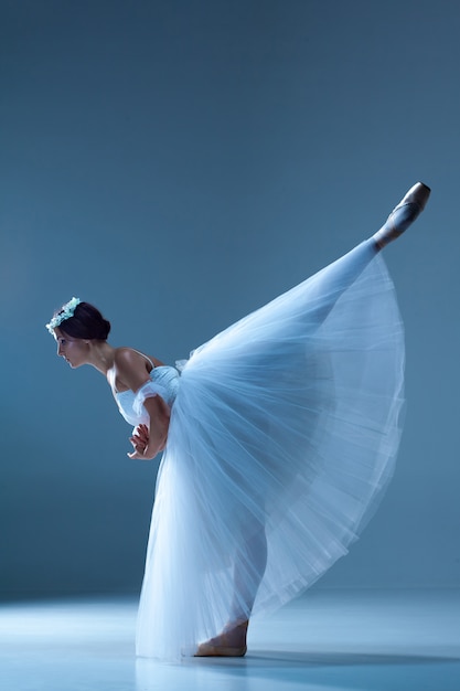 Gratis foto klassieke ballerina die op blauw danst