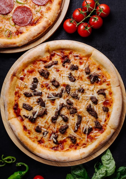 Klassieke Italiaanse pizza met gesmolten kaas, zwarte olijven en tomatensaus.