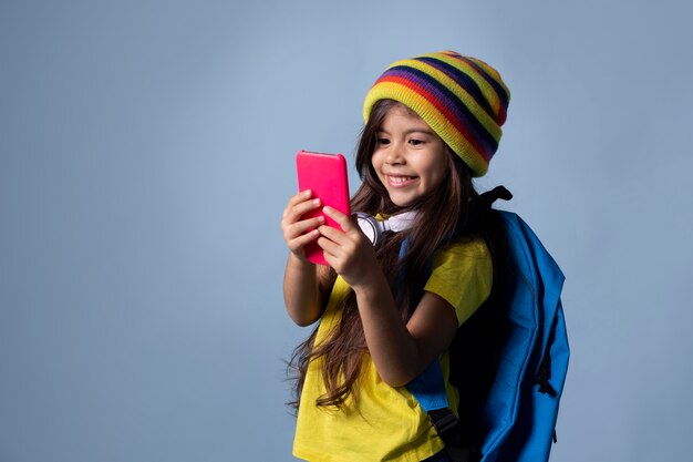 Klein Aziatisch schoolmeisje dat haar telefoon controleert