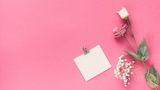 Klein blanco papier met verschillende bloemen op tafel