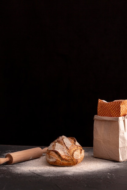 Gratis foto klein brood op donkere tafel