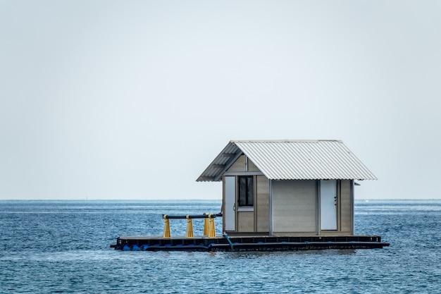 Klein houten huisje gelegen in het water van de oceaan