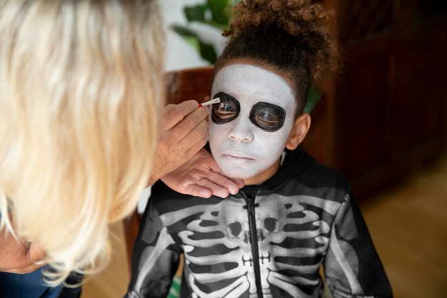 Klein meisje bereidt zich voor op Halloween met een skeletkostuum