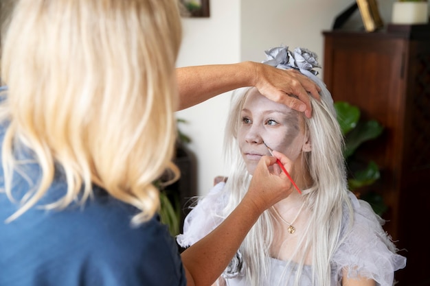 Klein meisje bereidt zich voor op Halloween met een spookkostuum