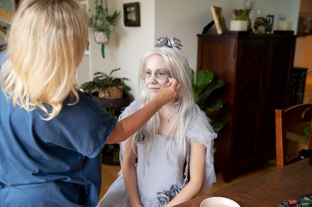 Klein meisje bereidt zich voor op Halloween met een spookkostuum