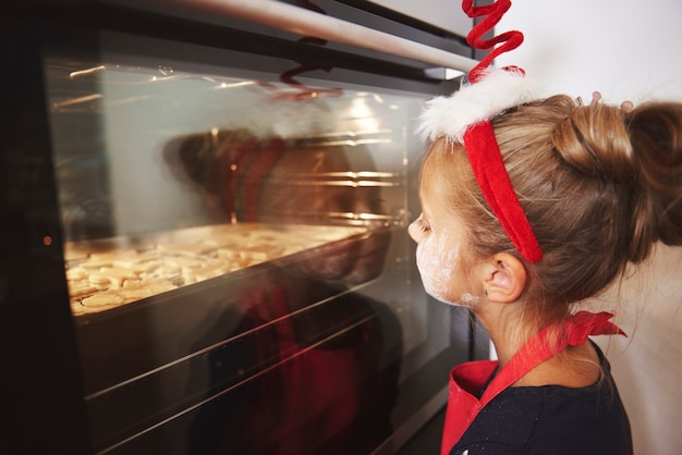 Gratis foto klein meisje dat op koekjes wacht