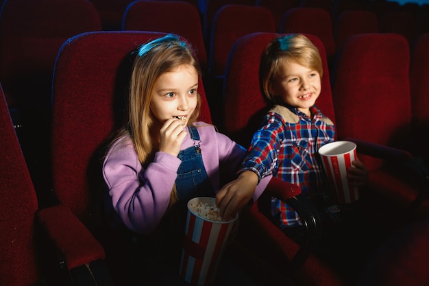 Klein meisje en jongen kijken naar een film in een bioscoop