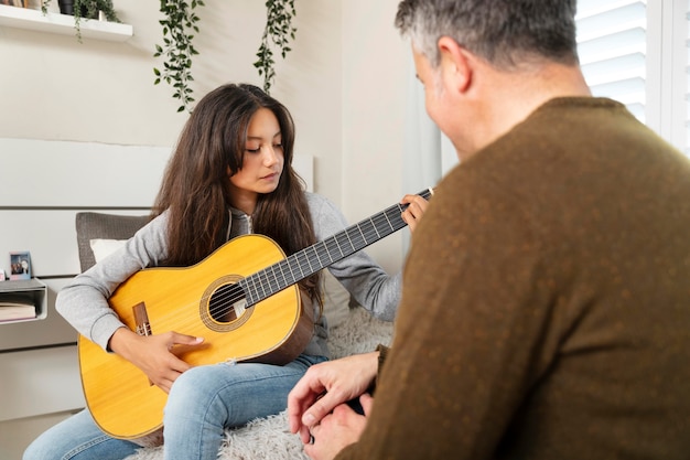 Gratis foto klein meisje leert gitaar spelen