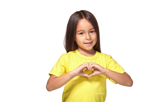 Klein meisje met haar handen in hartvormig geïsoleerd op de witte achtergrond