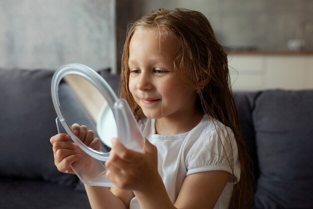 Klein meisje met hoofdluis die voor haar haar zorgt