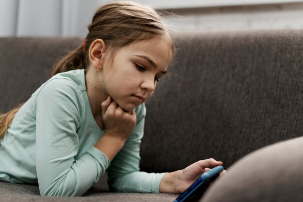 Klein meisje spelen op een smartphone thuis