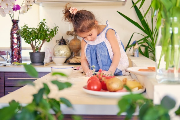 Klein meisje zit op een tafel in een keuken en probeert dieetpap te maken.