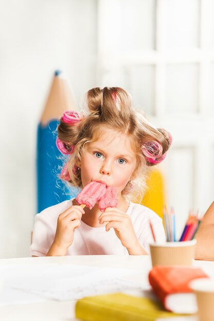 Klein meisje zitten en eten van ijs