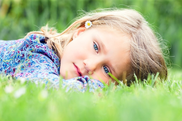 Klein schattig meisje liggend op gras