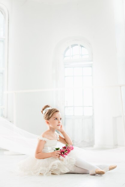 kleine balerina in witte tutu in de klas op balletschool