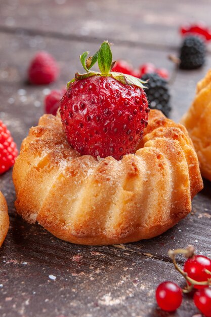 kleine cake met aardbei op bruin, fruit bessen bakken cake koekje