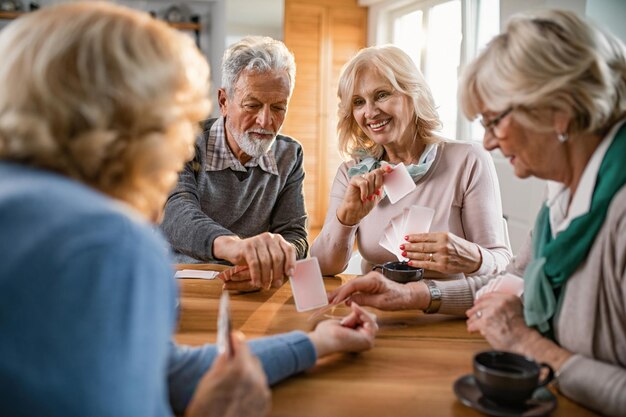 Kleine groep volwassen vrienden die thuis genieten van kaarten