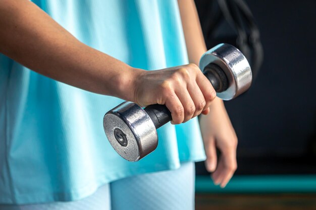 Kleine halter in de handen van een vrouw in de sportschool close-up