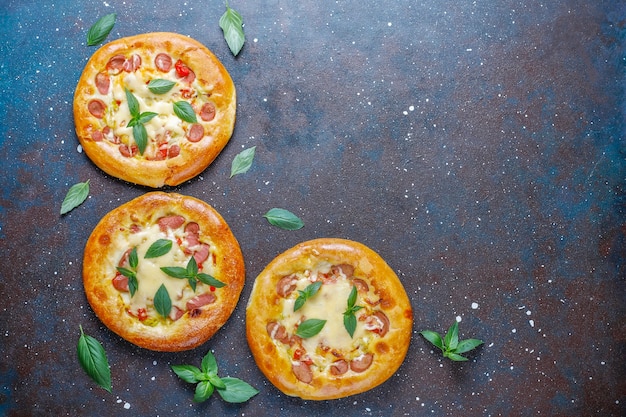 Kleine huisgemaakte pizza's vers met basilicum.