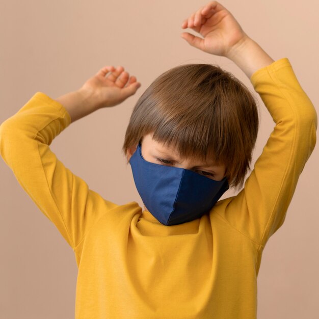 Kleine jongen die een medisch masker binnenshuis draagt