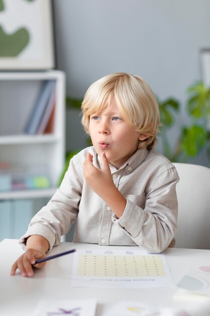 Kleine jongen die logopedie beoefent