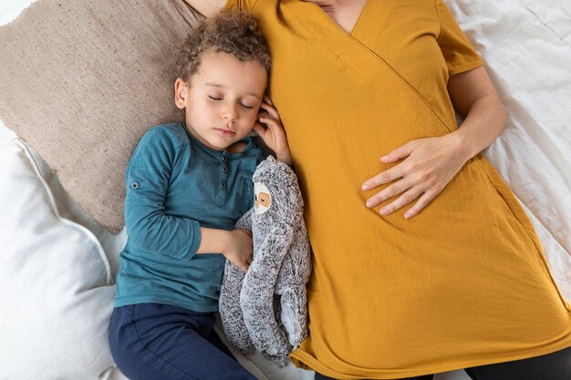 Kleine jongen die naast zijn moeder slaapt