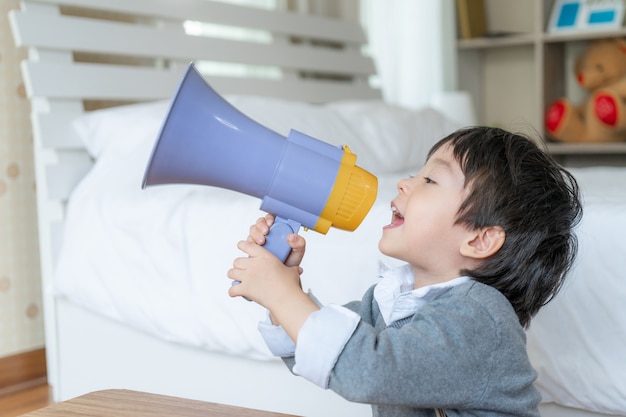 Kleine jongen geniet van praten met megafoon