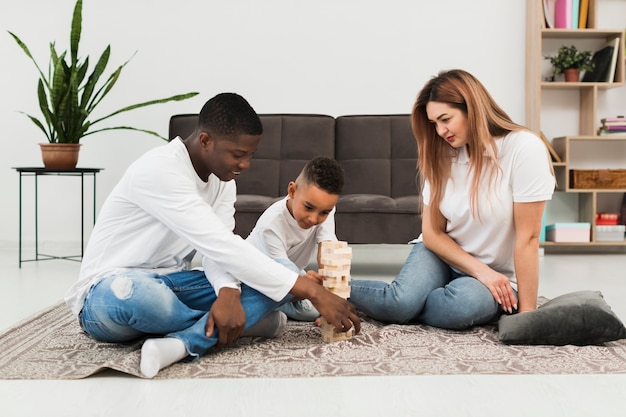 Kleine jongen houten toren spel spelen met zijn ouders