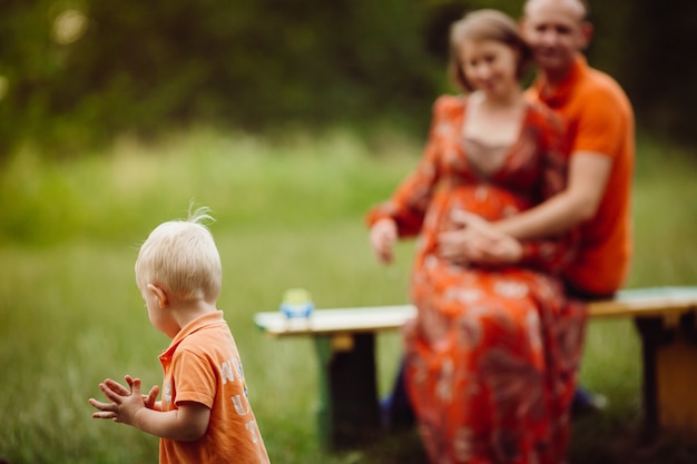 Kleine jongen loopt voordat zijn ouders op de bank zitten