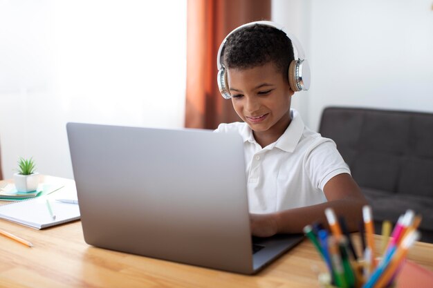 Kleine jongen luistert naar zijn leraar via een koptelefoon