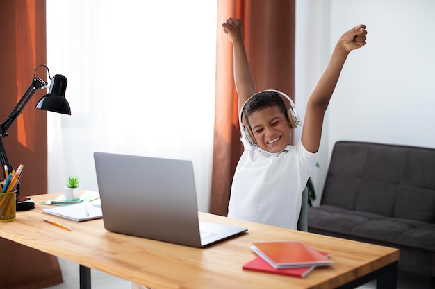 Gratis foto kleine jongen luistert naar zijn leraar via een koptelefoon