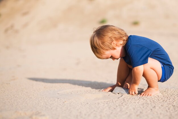 Kleine jongen op strand spelen met zand