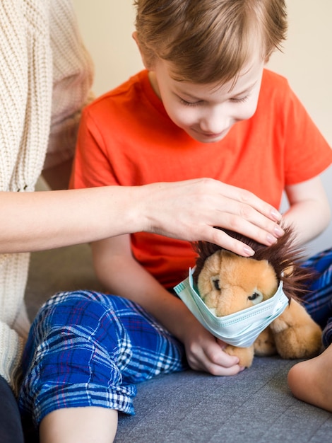 Kleine jongen speelgoed masker zetten