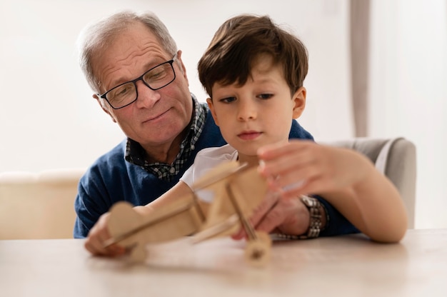 Kleine jongen speelt met zijn grootvader