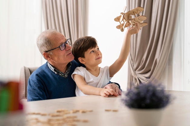 Kleine jongen speelt met zijn grootvader